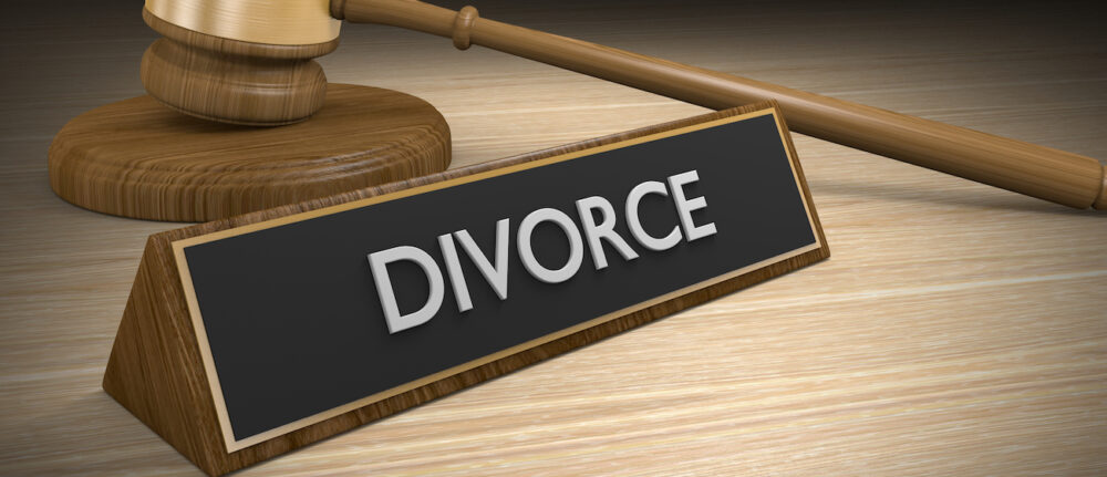 Legal concept of a wooden court gavel and a plaque with the word divorce.
