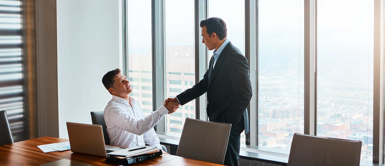 Shot of a client shaking hands with a lawyer in a corporate office