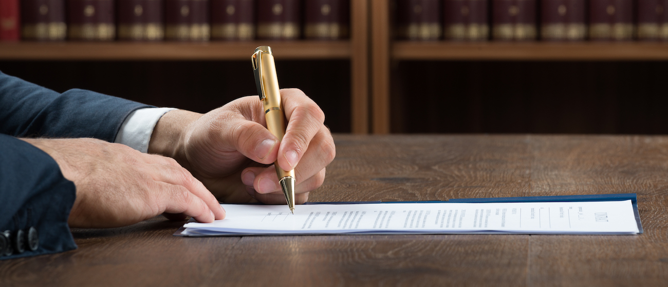lawyer writing on legal documents at desk in courtroom
