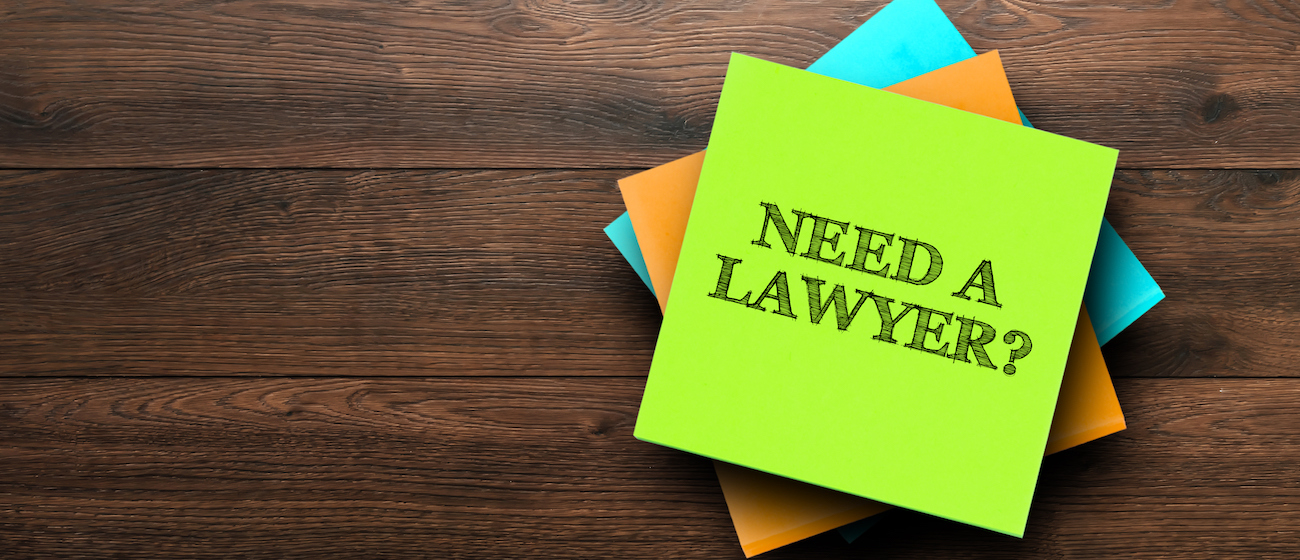 Need a lawyer, the phrase is written on multi-colored stickers, on a brown wooden background. Business concept, strategy, plan, planning.