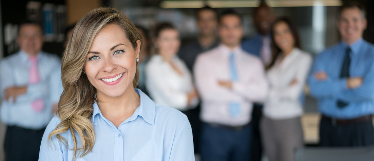 Successful business woman leading a group and looking at the camera at the office