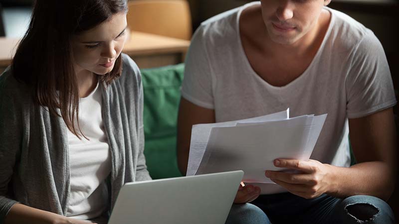 serious-millennial-couple-reviewing-consent-orders- A couple reading consent orders